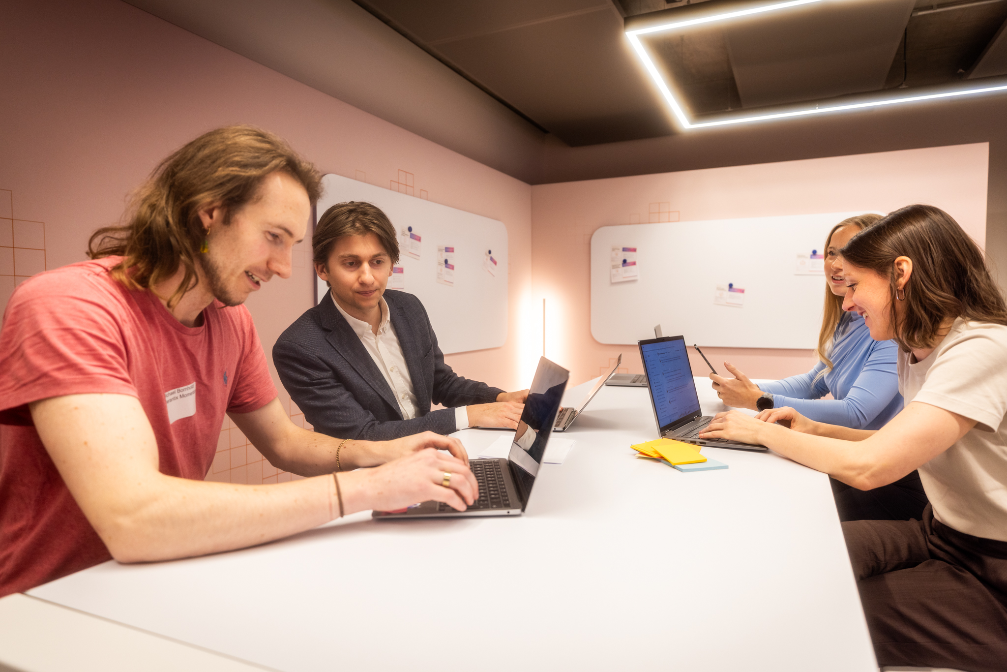 Vier Teilnehmende arbeiten in einer Hands-on Session an ihren Laptops und diskutieren gemeinsam einen ersten KI-Prototypen